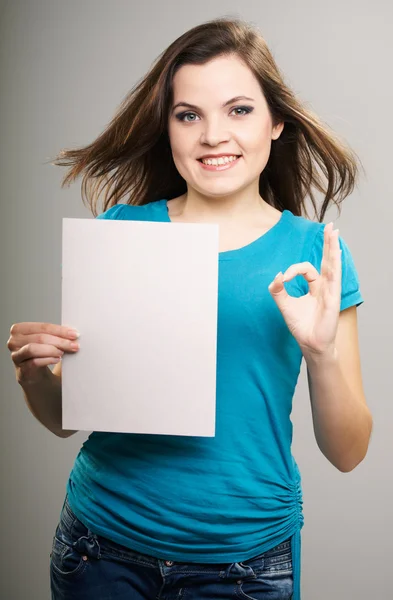 Ελκυστική νεαρή γυναίκα σε ένα μπλε πουκάμισο. γυναίκα κατέχει μια αφίσα και — Φωτογραφία Αρχείου