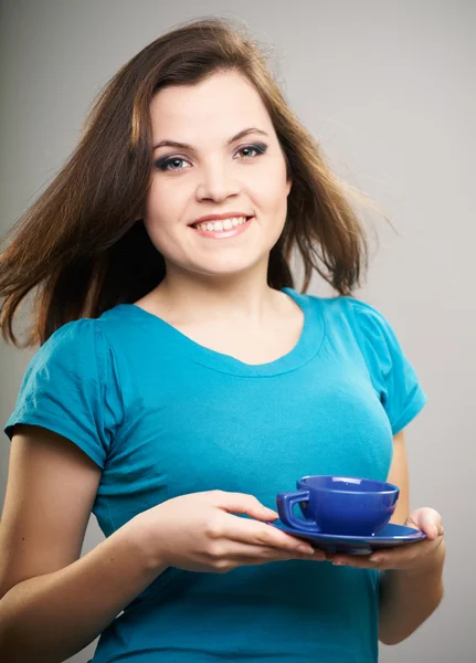 Attractive young woman in a blue shirt. A woman holding a blue c — Stock Photo, Image