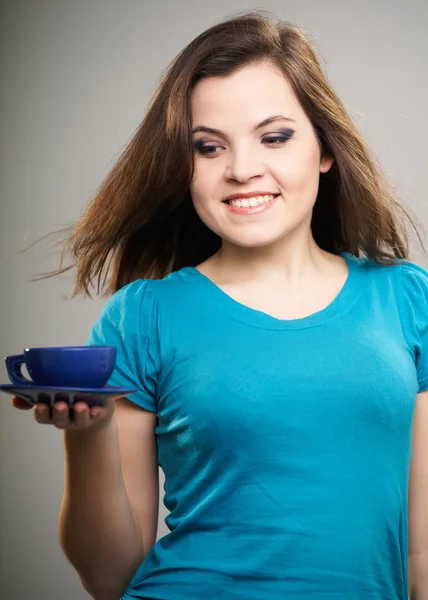 Attractive young woman in a blue shirt. A woman holding a blue c — Stock Photo, Image