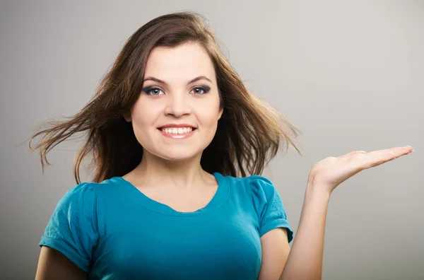 Una joven atractiva con una camisa azul. Mujer sostiene un imaginario —  Fotos de Stock