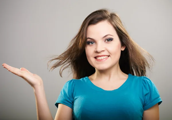 Una joven atractiva con una camisa azul. Mujer sostiene un imaginario — Foto de Stock