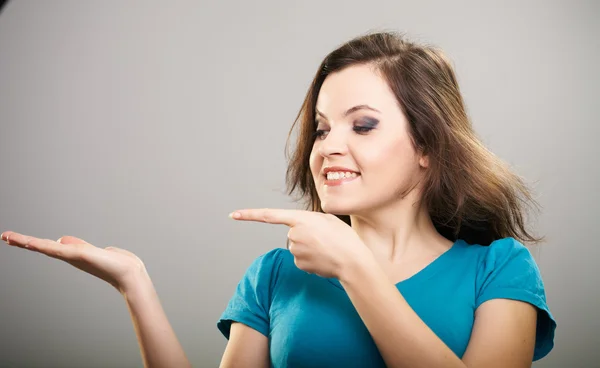 Attraktiv ung kvinna i en blå skjorta. kvinnan håller en imaginär — Stockfoto