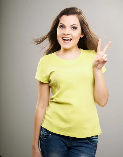 Una joven atractiva con una camisa amarilla. Mujer muestra un símbolo o — Foto de Stock