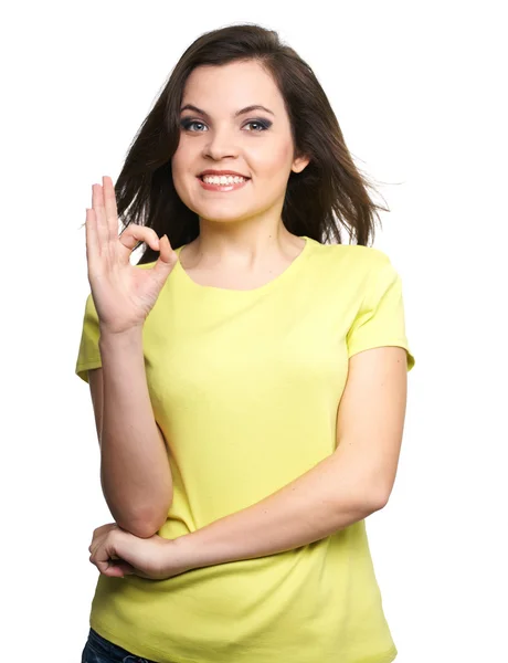 Una joven atractiva con una camisa amarilla. Mujer muestra un signo oka — Foto de Stock