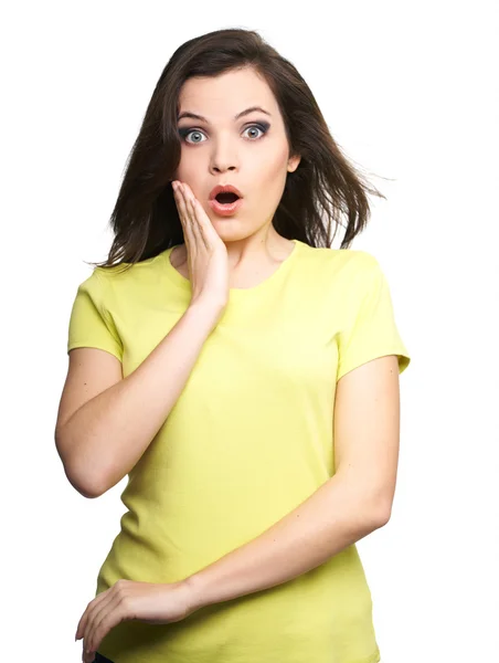Surprised young woman in a yellow shirt. Hair in motion. — Stock Photo, Image