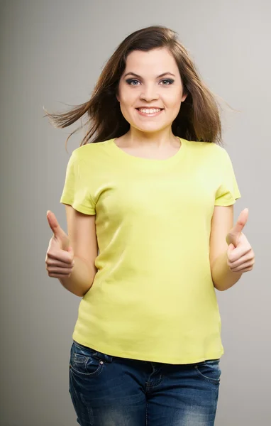 有吸引力的年轻女人在黄色上衣显示的拇指 u 的女人 — 图库照片