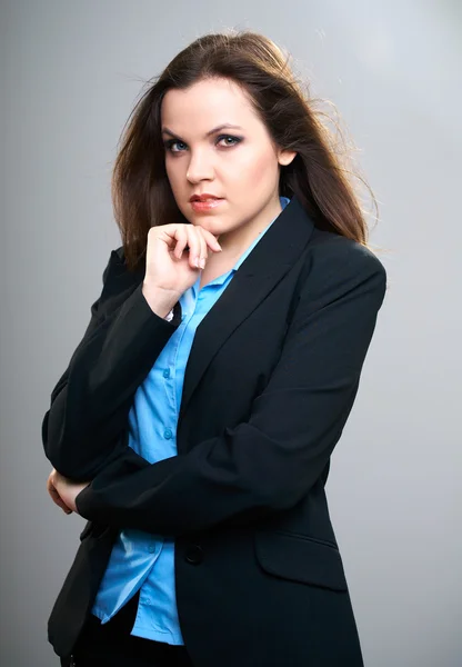 Uma jovem atraente com um casaco preto. Cabelo em movimento . — Fotografia de Stock