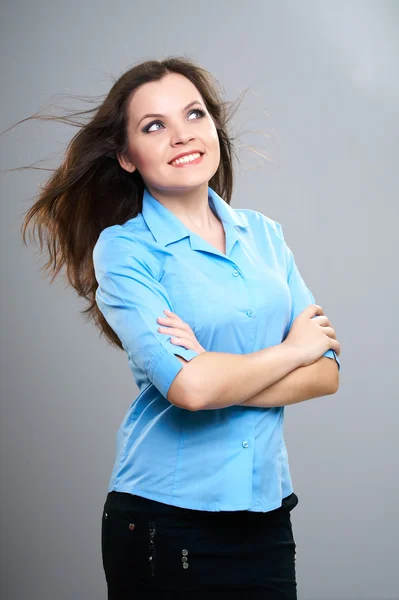 Attractive young woman in a blue shirt. Looking into the upper-l — Stock Photo, Image