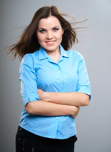 Aantrekkelijke jonge vrouw in een blauw shirt. haar in beweging. — Stockfoto