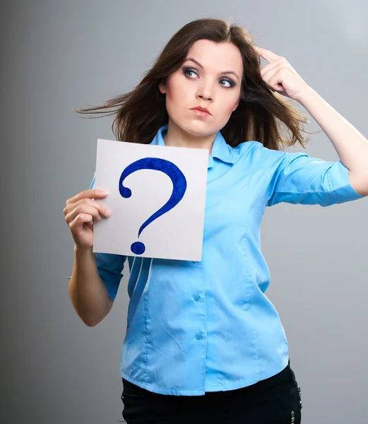 Attractive young woman in a blue shirt. Woman thinks and holds p — Stock Photo, Image