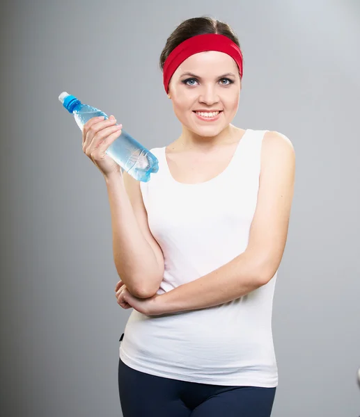 Привлекательная молодая женщина в спортивной одежде. Женщина держит бутылку. — стоковое фото