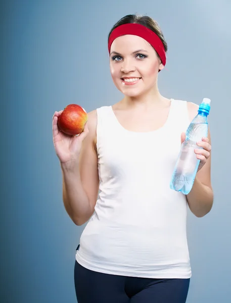 Mujer joven atractiva en ropa de fitness. Mujer sosteniendo una botella o —  Fotos de Stock