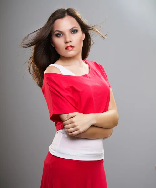 Una joven atractiva con una camisa roja. Cabello en movimiento —  Fotos de Stock