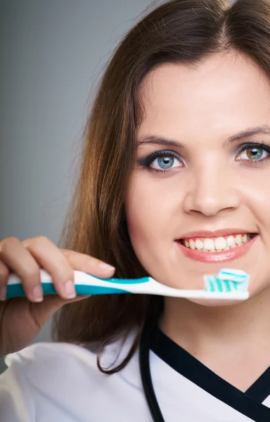 Attractive young nurse. Woman holding a toothbrush with toothpas — Stock Photo, Image