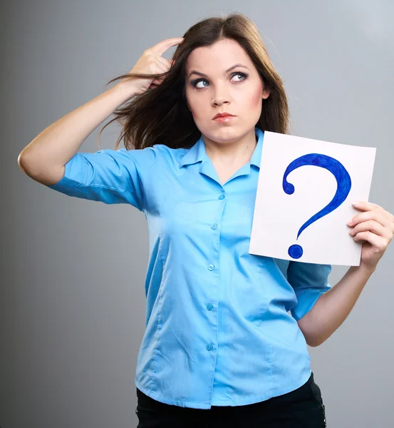 Attractive young woman in a blue shirt. Woman thinks and holds p — Stock Photo, Image