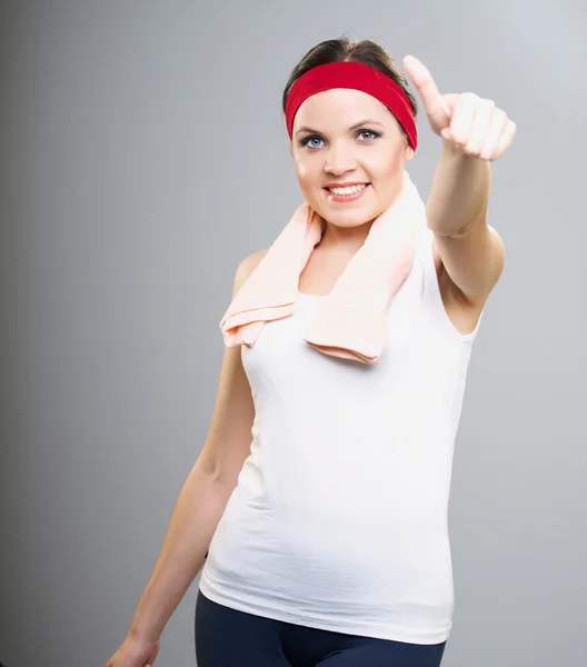 Attractive young woman in a white sports shirt. Woman showing th — Stock Photo, Image