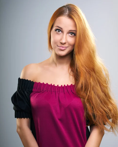 Attractive young woman with long red hair in a red dress. — Stock Photo, Image