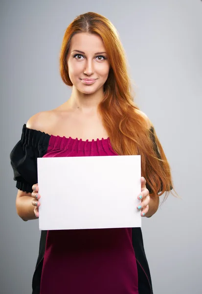 Attractive young woman with long red hair. Holds a poster. — Stock Photo, Image