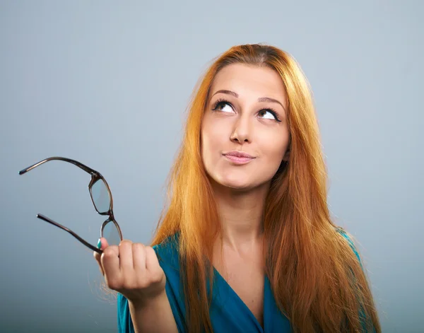 Attraktiv ung kvinna i en blå klänning. innehar glasögon och lookin — Stockfoto