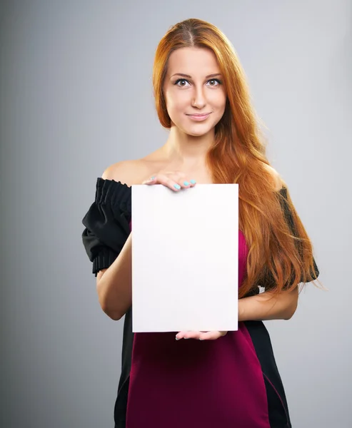 Atraktivní mladá žena dlouhé červené vlasy. drží plakát. Royalty Free Stock Obrázky