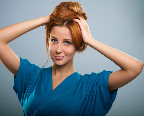 Atraktivní mladá žena s červenými vlasy v modrých šatech. — Stock fotografie