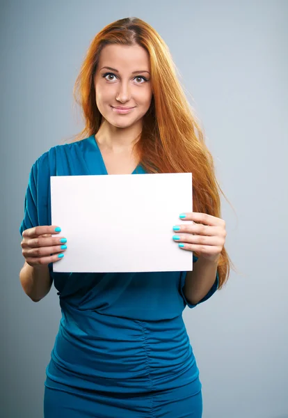 Attraktiv ung kvinna med långa röda hår. innehar en affisch. — Stockfoto