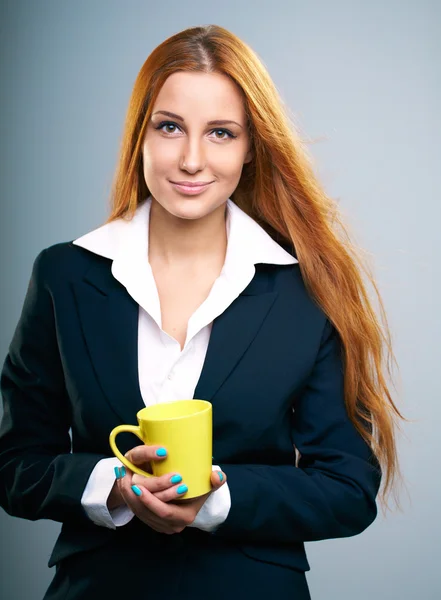 Attractive young woman in a black jacket. Holds a yellow cup. — Stock Photo, Image