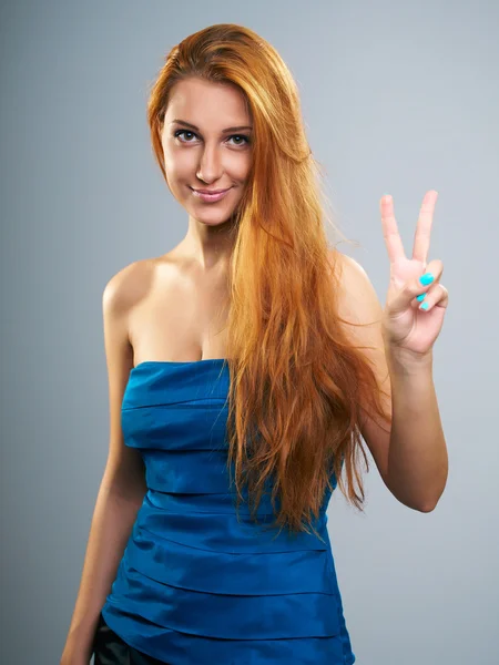 Attractive young woman in a blue blouse. Shows the symbol of vic — Stock Photo, Image