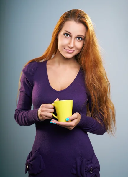 Attractive young woman in a lilac dress. Woman holds a yellow cu — Stock Photo, Image