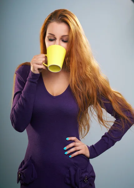 Attractive young woman in a lilac dress. Woman holds a yellow cu — Stock Photo, Image
