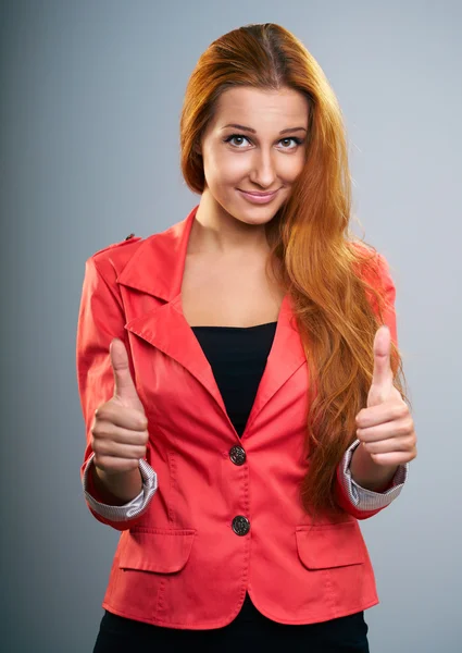 Una joven atractiva con una chaqueta roja. Mostrando pulgares hacia arriba con b —  Fotos de Stock