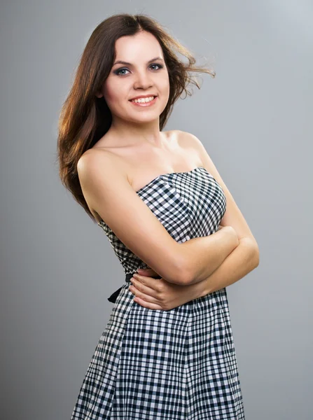 Attractive young woman in a checkered dress. — Stock Photo, Image