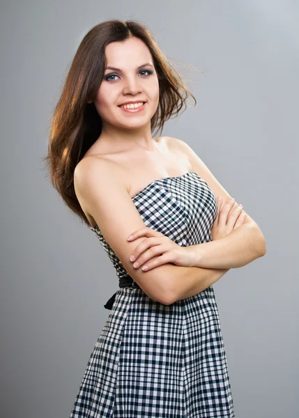 Attractive young woman in a checkered dress. — Stock Photo, Image