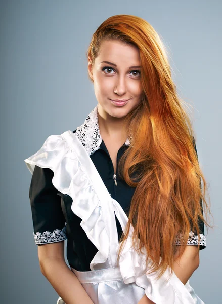 Attractive young woman in a school uniform. Long red hair. — Stock Photo, Image