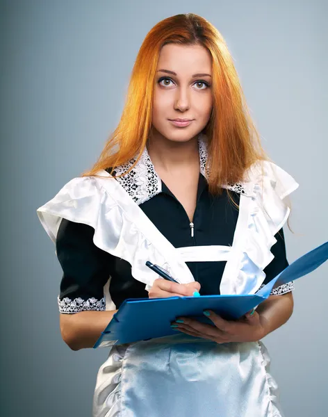 Atrakcyjna młoda kobieta w mundurek szkolny. posiada niebieski folder. — Zdjęcie stockowe