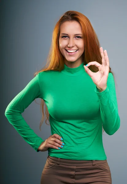 Aantrekkelijke jonge vrouw in een groen shirt. toont ondertekenen oke. — Stockfoto