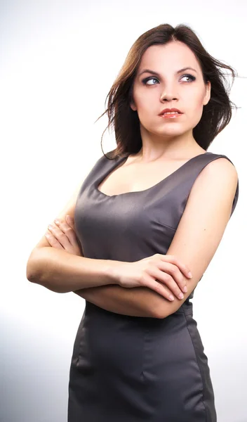 Attraktiv ung kvinna i en grå business klänning. titta in th — Stockfoto