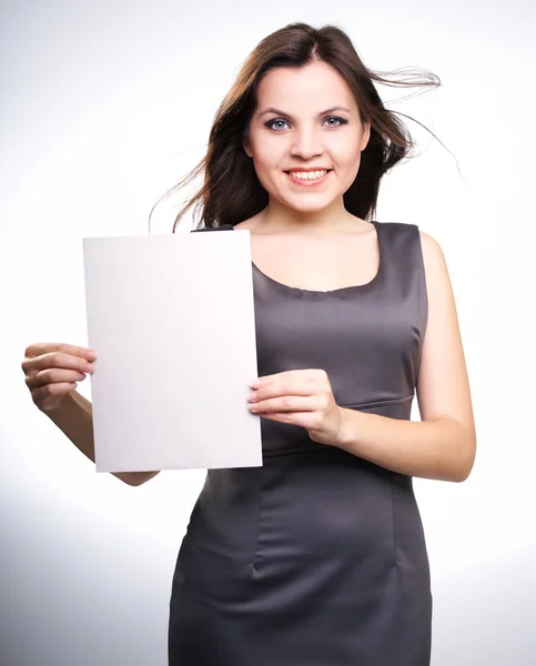 Atractiva joven con un vestido gris de negocios. Sostiene un cartel . —  Fotos de Stock