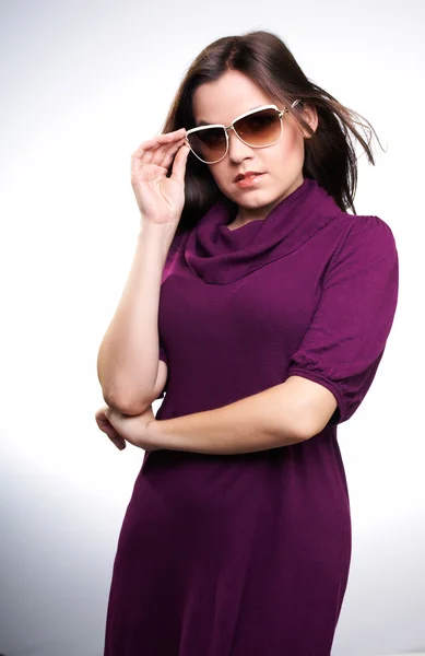Attraktiv ung kvinna i en röd klänning och solglasögon. — Stockfoto