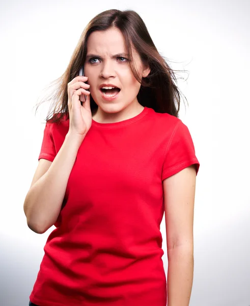 Удивлённая молодая женщина в красной рубашке. Женщина разговаривает по мобильному телефону — стоковое фото