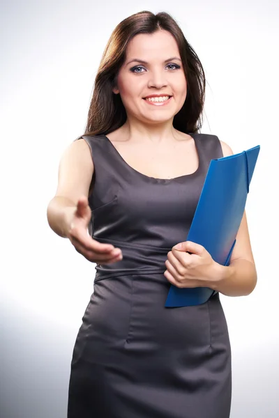 Attractive young woman in a gray business dress. Woman holds a b — Stock Photo, Image