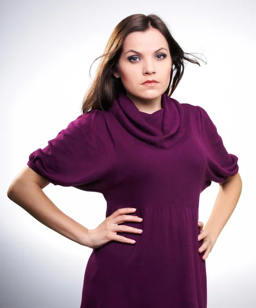 Young attractive girl in a claret dress with hands on her hips — Stock Photo, Image