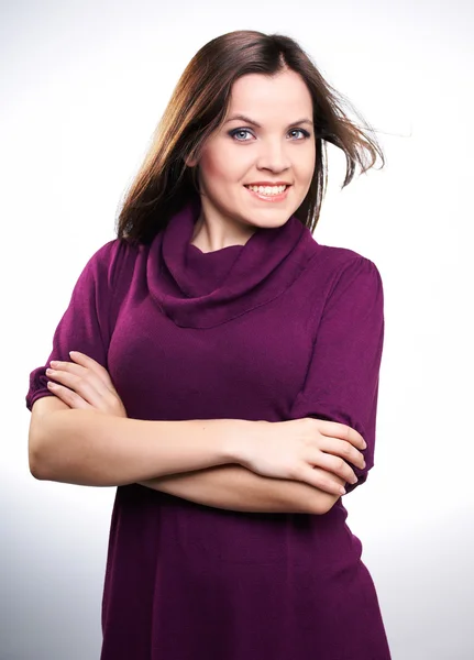 Atraktivní usměvavá mladá žena v purpurových šatech. — Stock fotografie