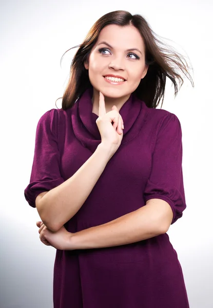 Happy young woman in a claret dress. Woman holds her finger on h — Stock Photo, Image