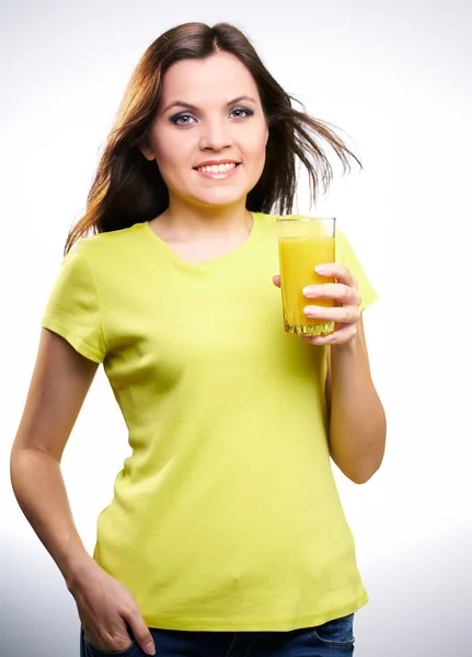 Young beautiful girl in a yellow shirt holding a orange juice — Stock Photo, Image