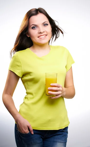 Young beautiful girl in a yellow shirt holding a orange juice — Stock Photo, Image