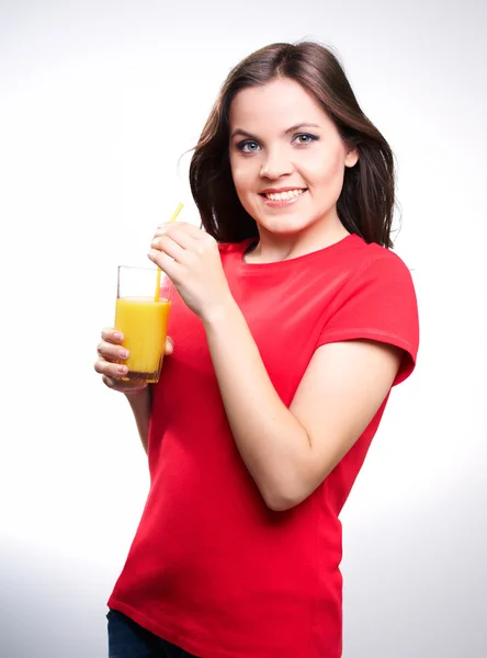 Young beautiful girl in a red shirt holding a orange juice — Stock Photo, Image