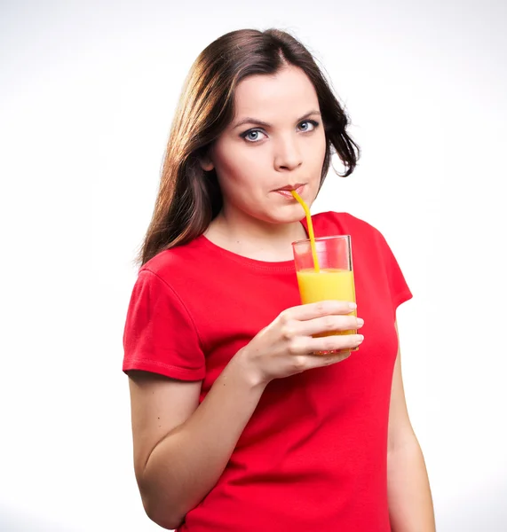 Atractiva joven en una camisa roja beber jugo de naranja — Foto de Stock