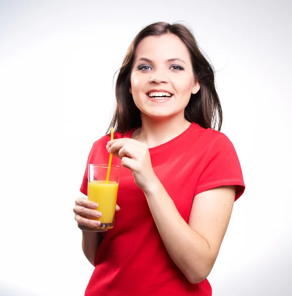 Joven hermosa chica en una camisa roja sosteniendo un jugo de naranja — Foto de Stock