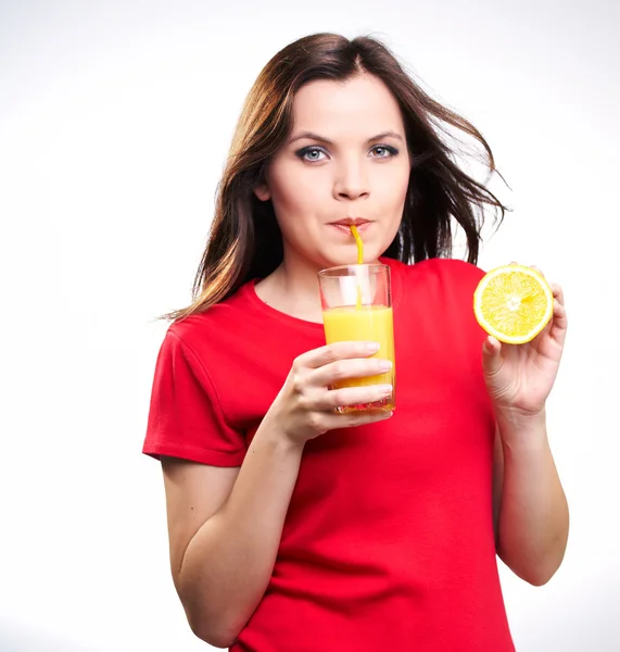 Attractive young girl in a red shirt drinking orange juice — Stock Photo, Image